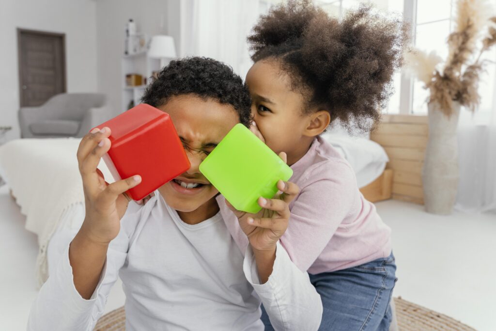 front view two siblings playing with cubes