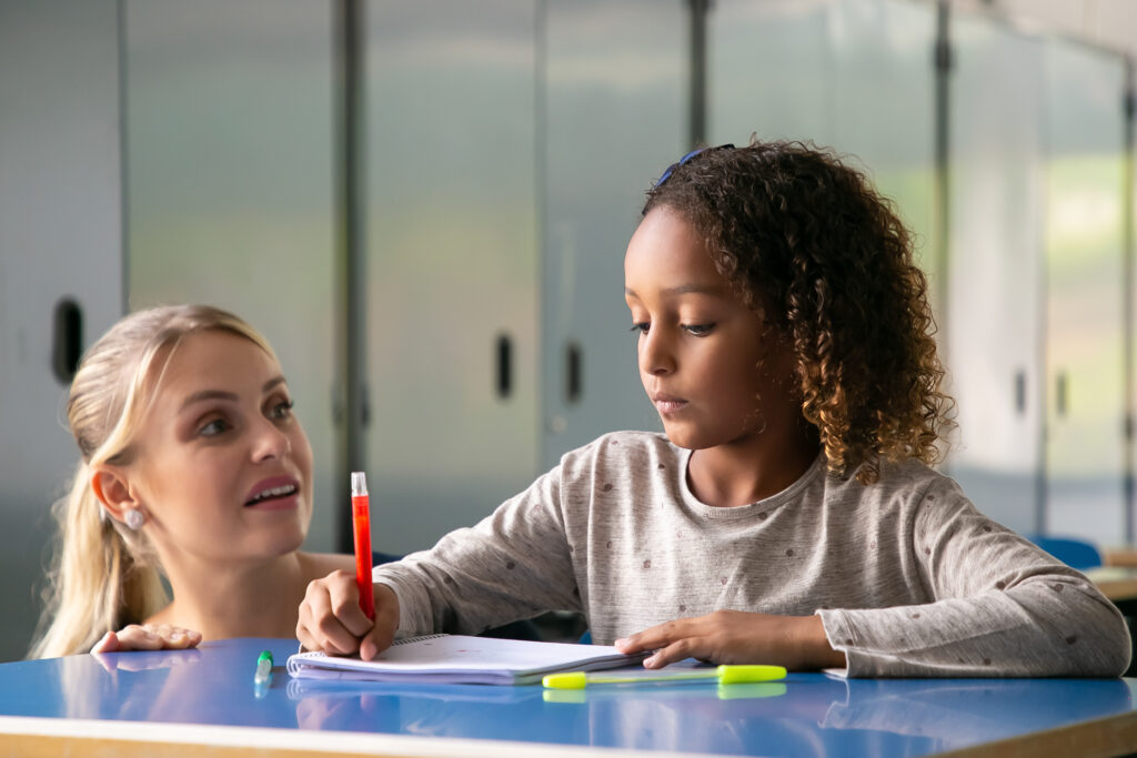Helping preteens strengthen critical thinking and decision-making positive female school teacher helping curly haired girl